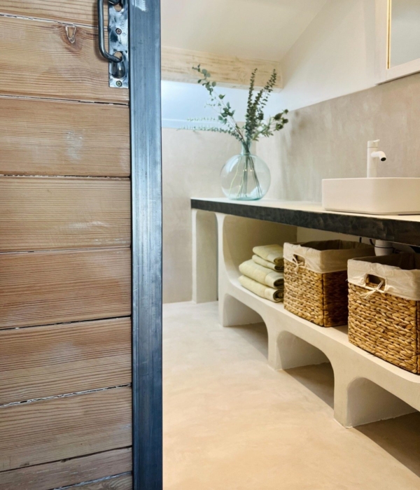 Rustic bathroom with a sink, wicker baskets and a plant.