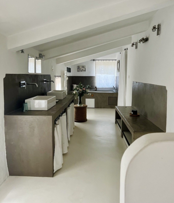 Modern and minimalist bathroom with concrete walls and clean lines.
