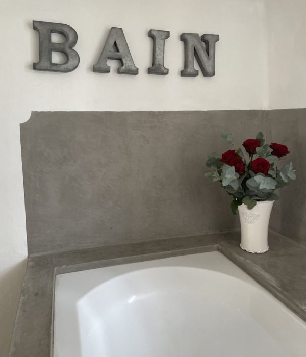 An elegant bathroom cabinet with red roses and a white vase.