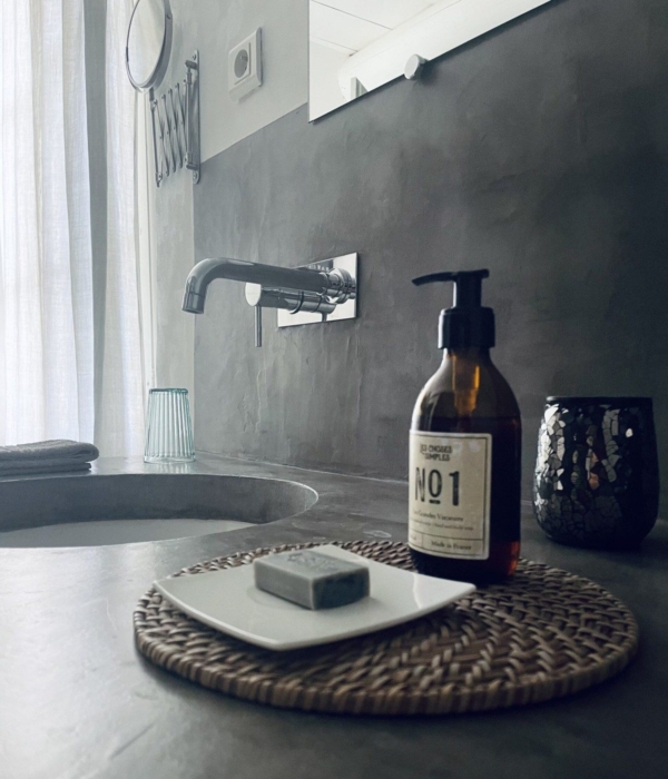 A stone sink with a soap dispenser and a decorative tray.