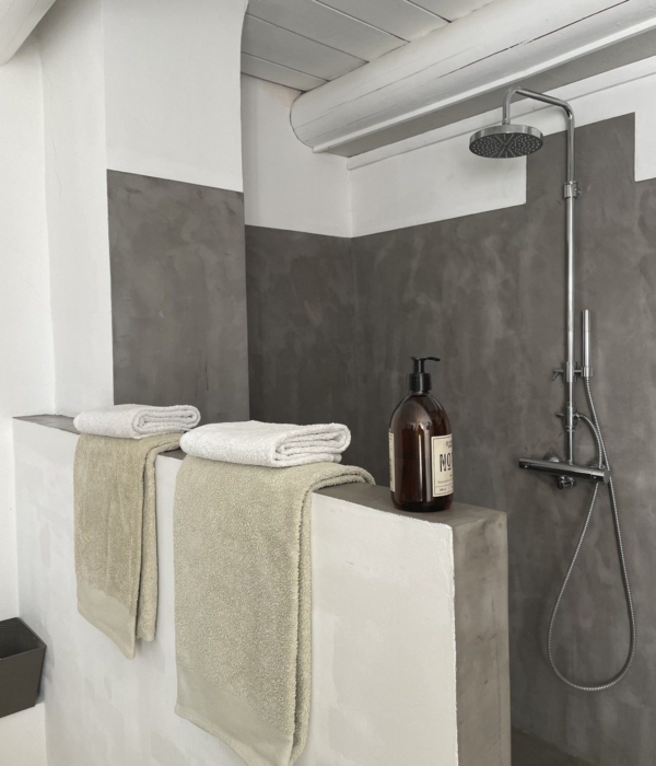 Modern shower with white towels and elegant soap in a minimalist interior.