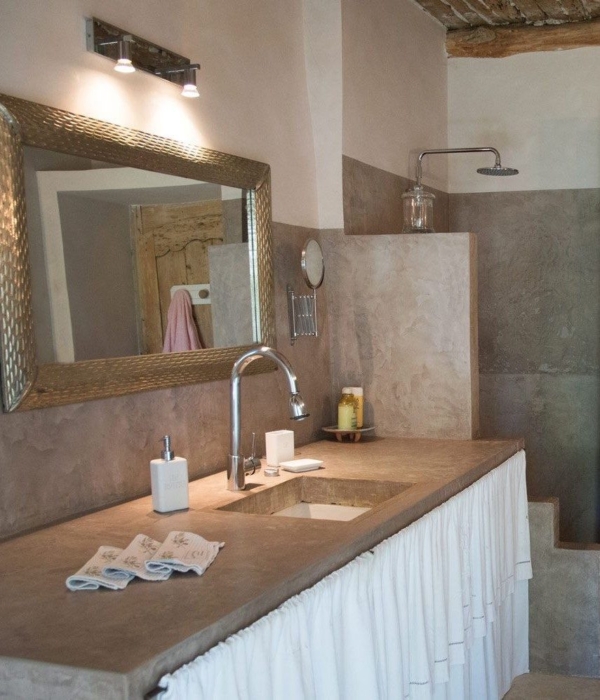 Rustikales Badezimmer mit Spiegel, Dusche und sichtbaren Holzelementen.