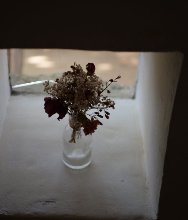 Eine mit Blumen gefüllte Vase steht auf einem Tisch