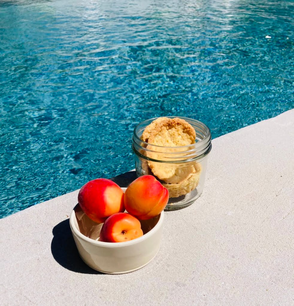 Des pêches et des biscuits au bord de la piscine, un moment gourmand et relaxant.