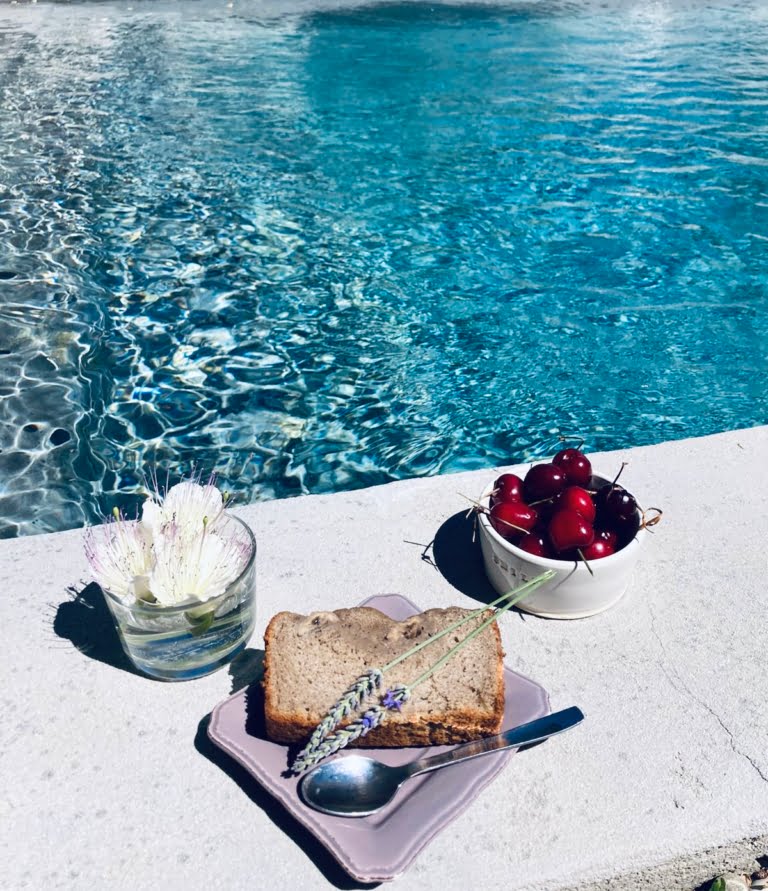 Un délicieux pain aux cerises et fleurs près d'une piscine scintillante.