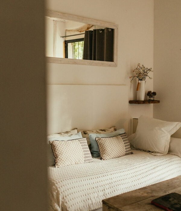 une chambre avec une couverture blanche et des oreillers blancs