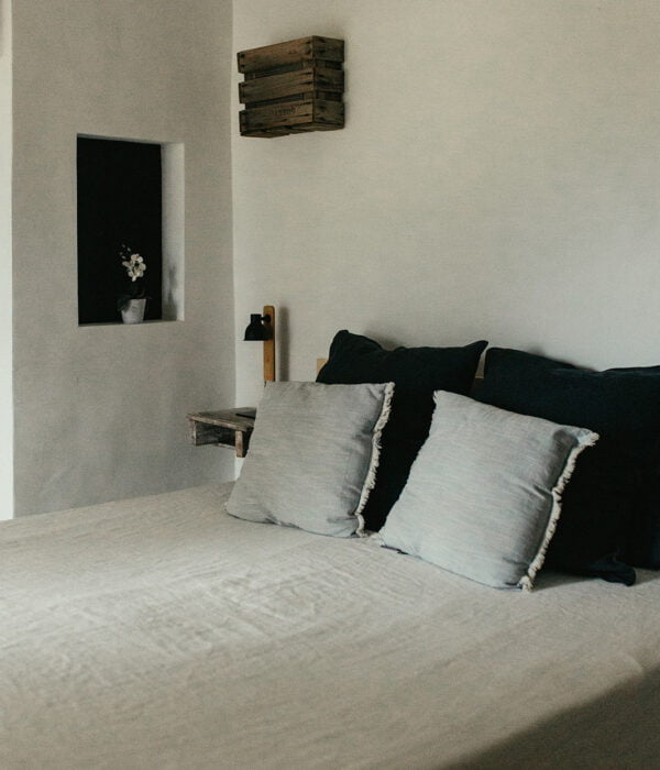 un lit blanc assis dans une chambre à côté d'un mur