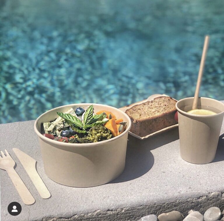 a cup of soup and a sandwich on a table