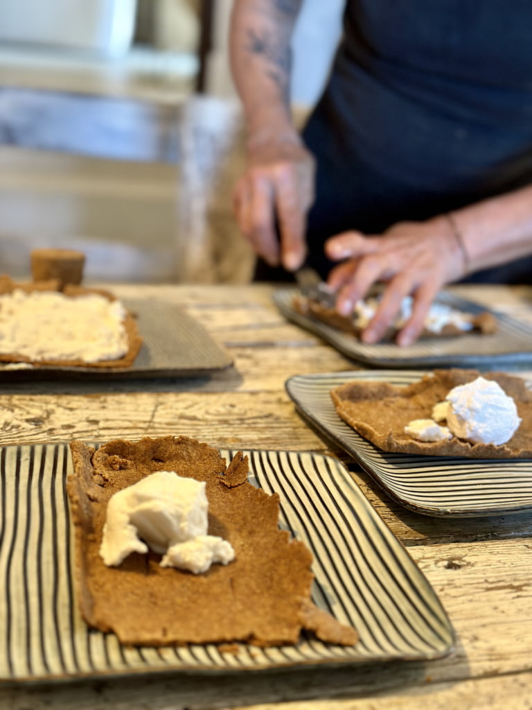 Shortbread-Kekse, dekoriert mit Eiscreme, auf einem rustikalen Tisch.