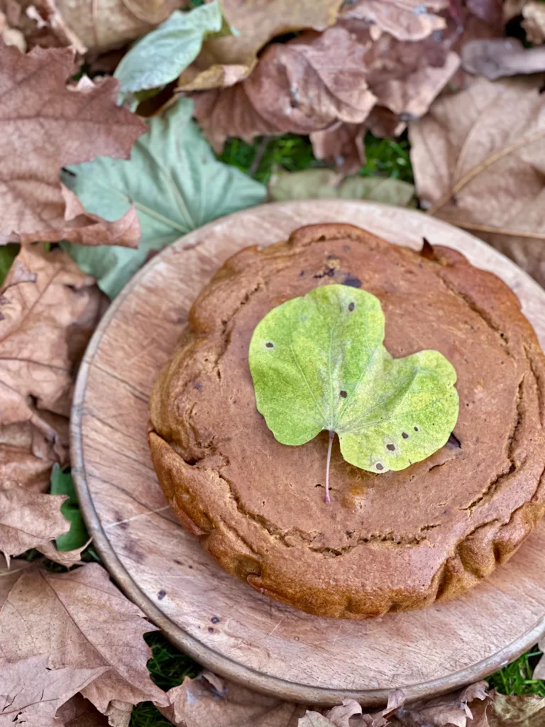 Ein köstlicher Kuchen in herbstlichen Farben, verziert mit einem frischen grünen Blatt.