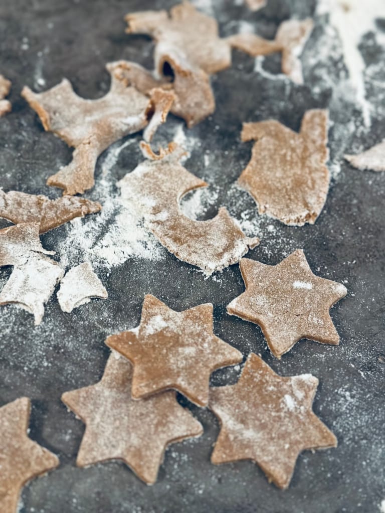 Des biscuits en forme d'étoiles, recouverts de farine, prêts pour Noël.