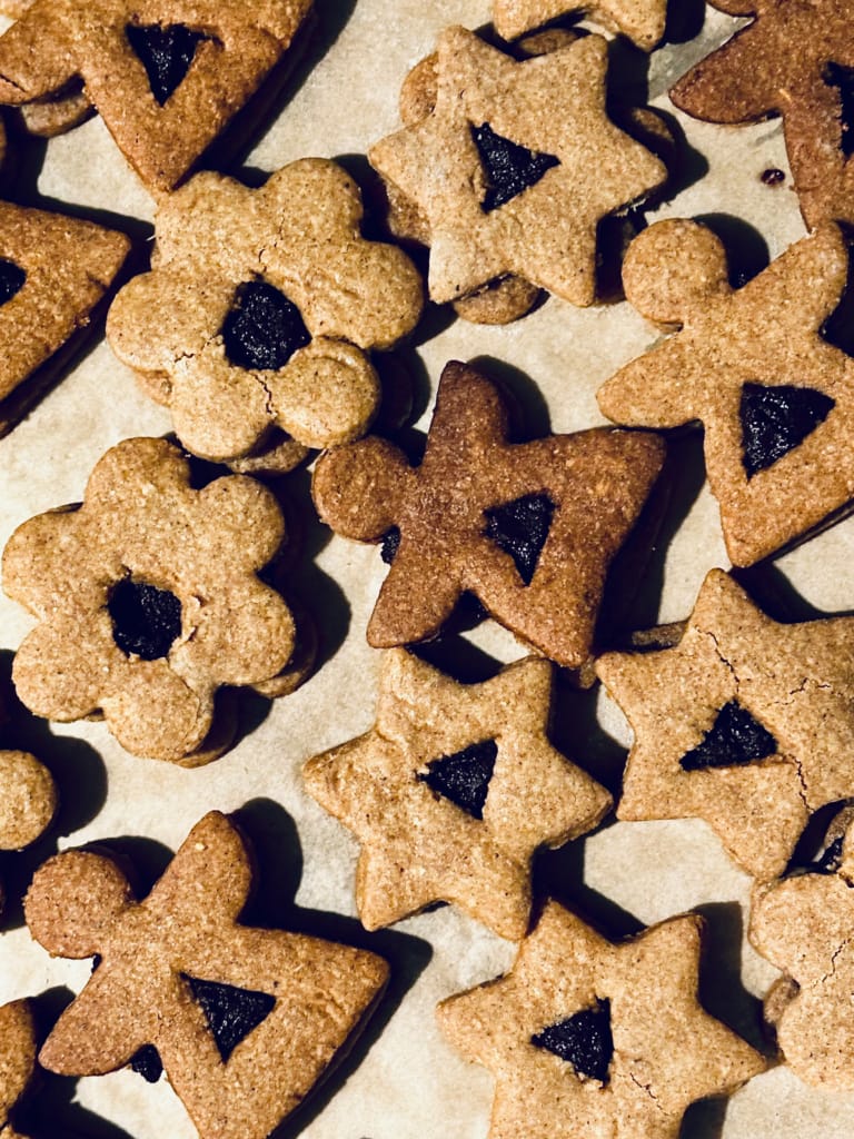 Blumen- und sternförmige Kekse, auf Pergamentpapier gebacken.