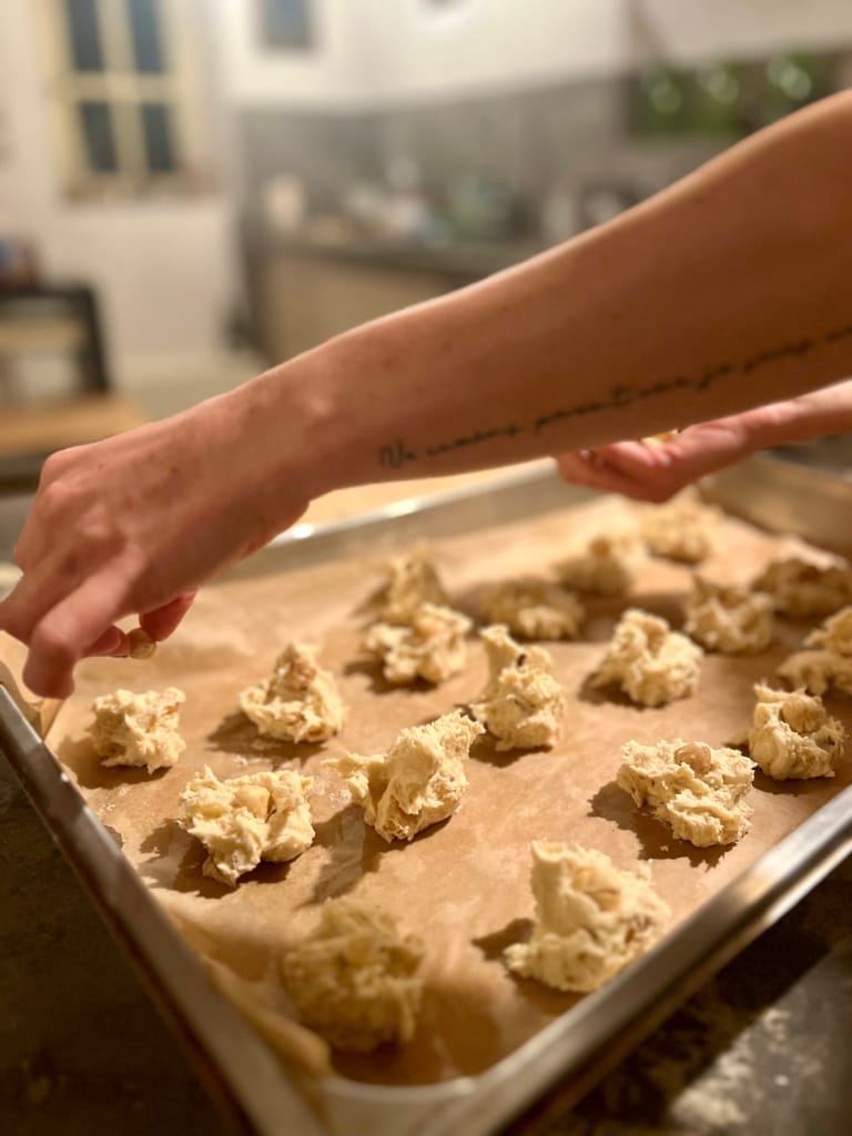 Des biscuits en forme de petites boules sont disposés sur une plaque de cuisson.
