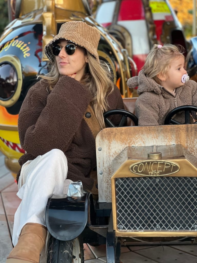 A woman and her daughter are enjoying an amusement park attraction.