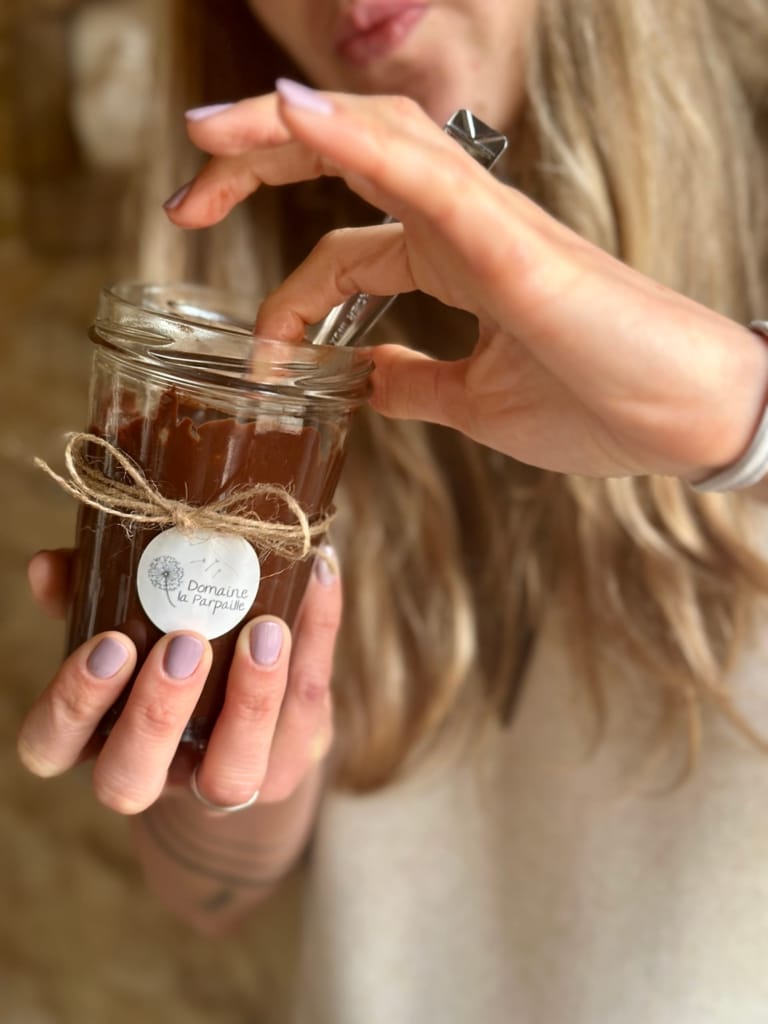 A woman opens a jar of artisanal jam from the La Parpaille estate.