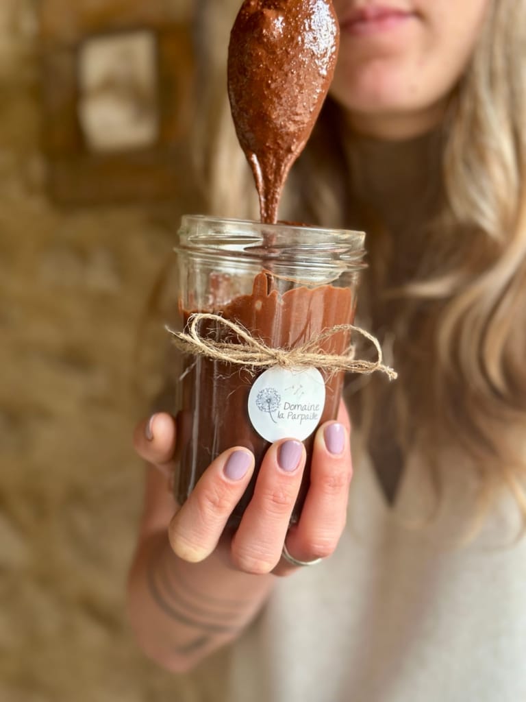 A hand holds a jar of chocolate spread from the La Parpalette estate.