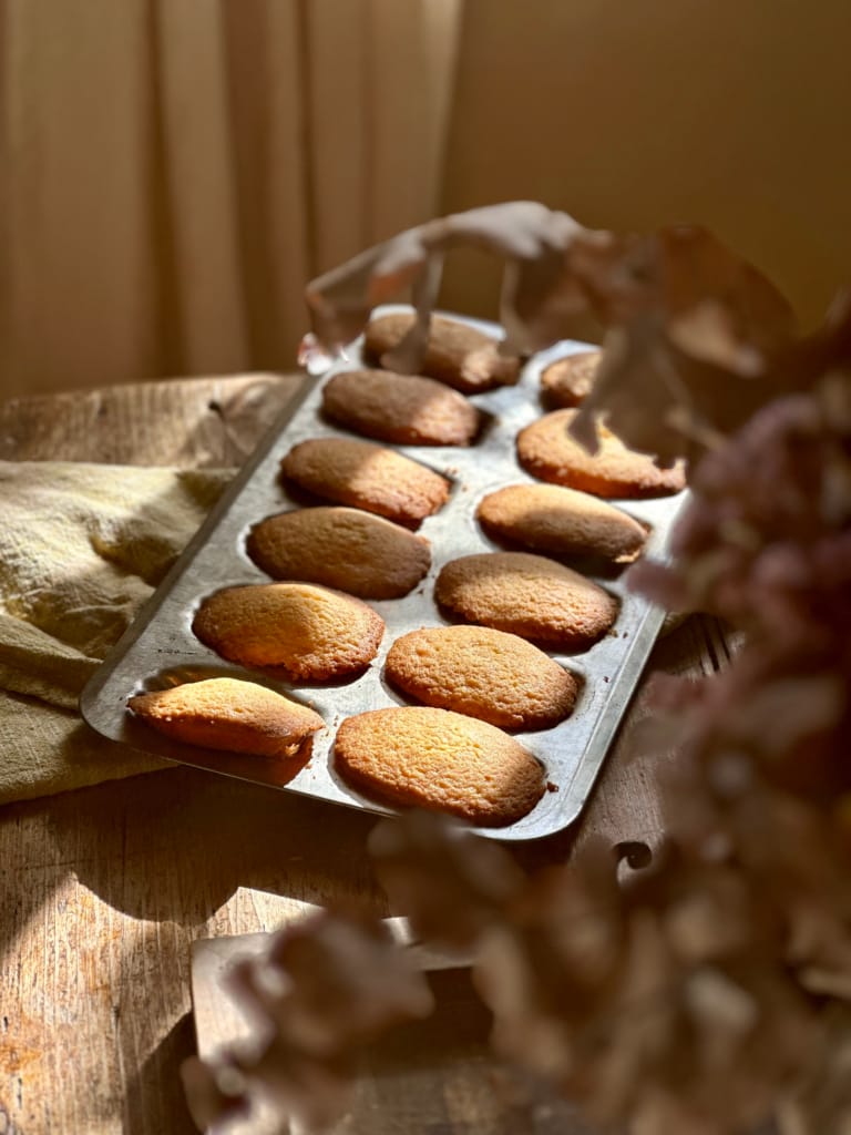 Goldene Madeleines in einer Form, eine köstliche Leckerei zum Teilen.