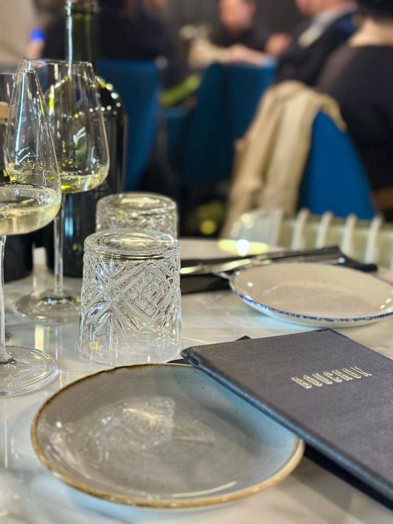An elegant table with glasses and a menu, ready for a refined meal.