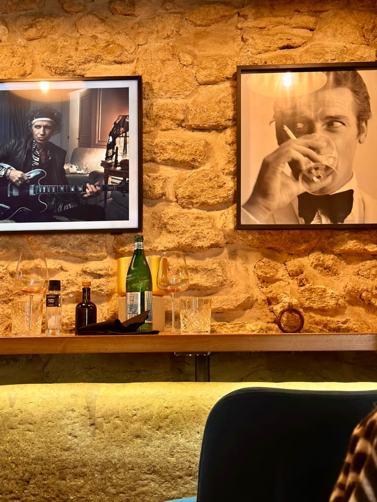 Eine gemütliche Bar mit Porträts von Rockstars und einem eleganten Herrn.