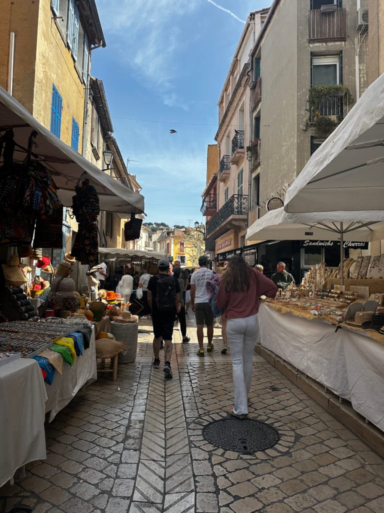 Une rue animée d'une ville espagnole, bordée de boutiques et de stands de marché.