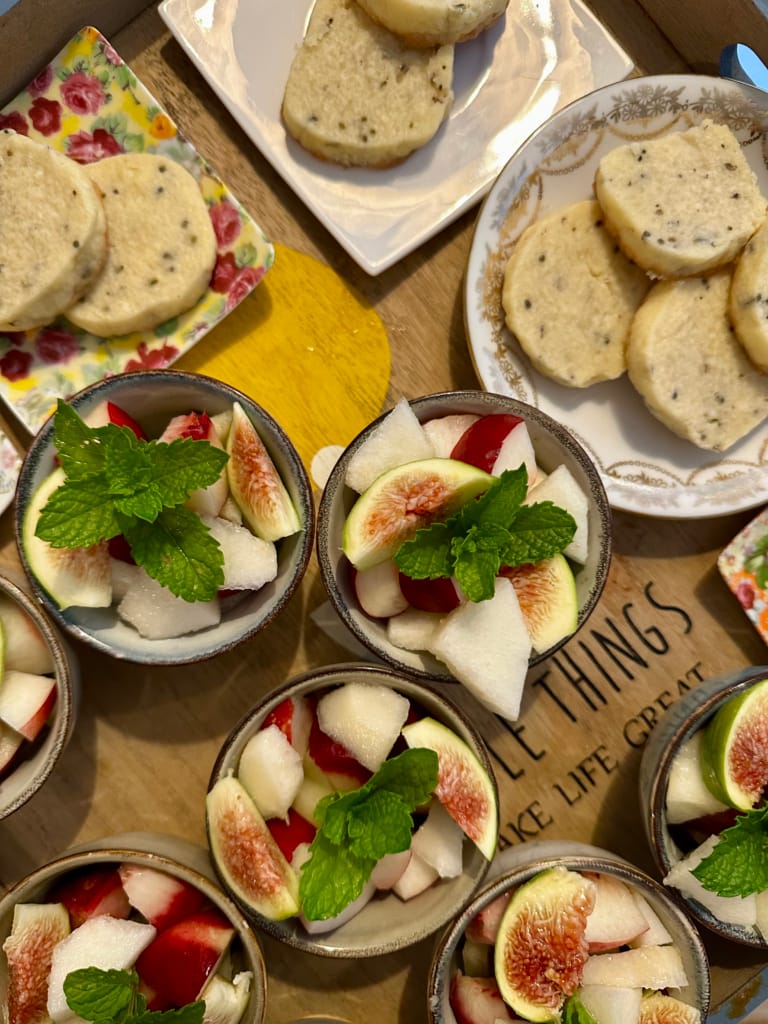 Auswahl an frischen Desserts: Feigen, Melone und Kekse, garniert mit Minze.