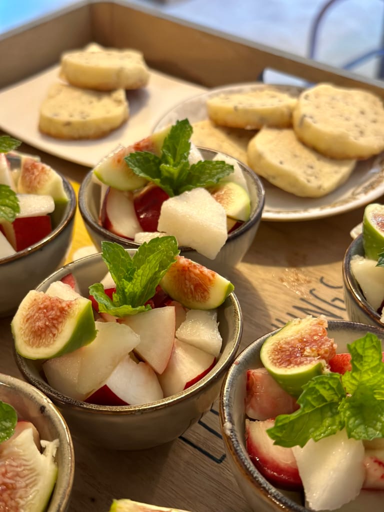 Frischer und farbenfroher Obstsalat, mit Minze garniert, serviert in kleinen Schälchen.