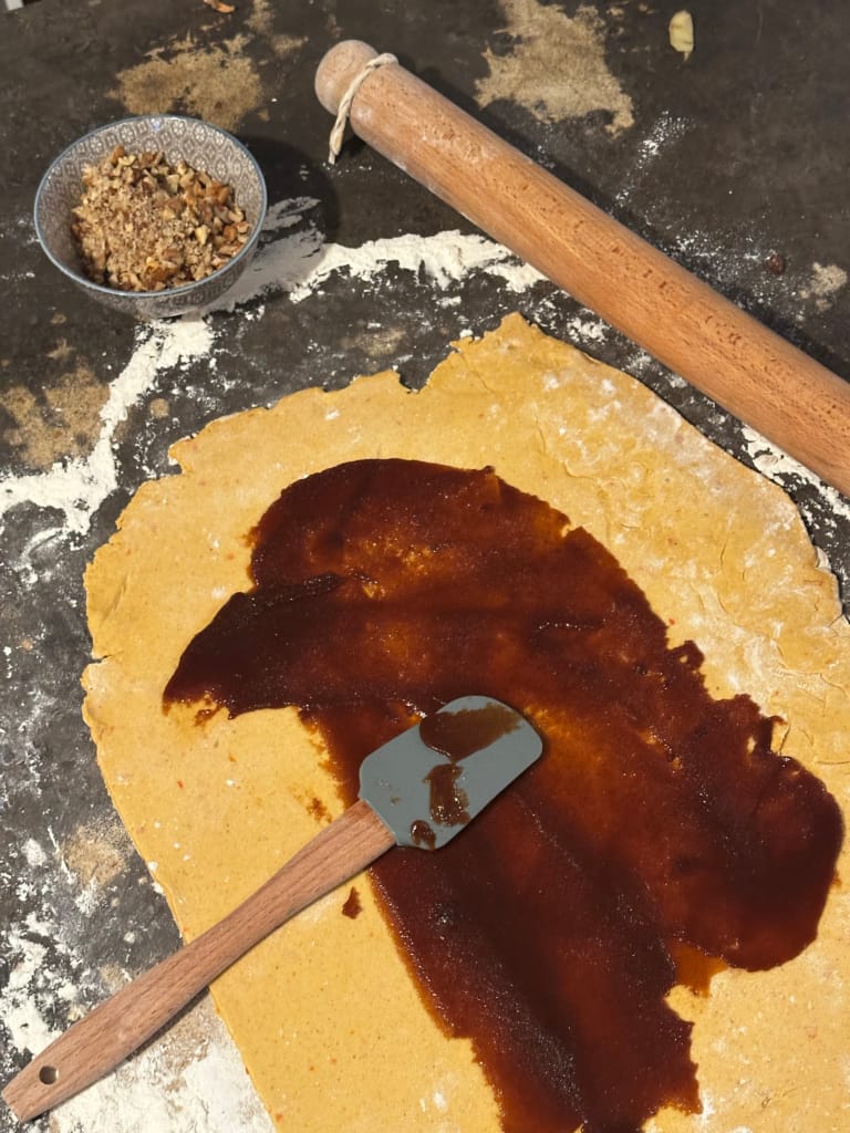 A pie crust spread with caramel, ready to be filled.