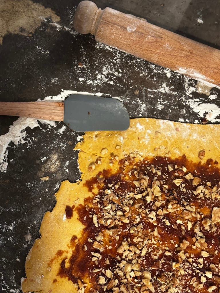A crispy pie crust covered with nuts and caramel, ready to be baked.