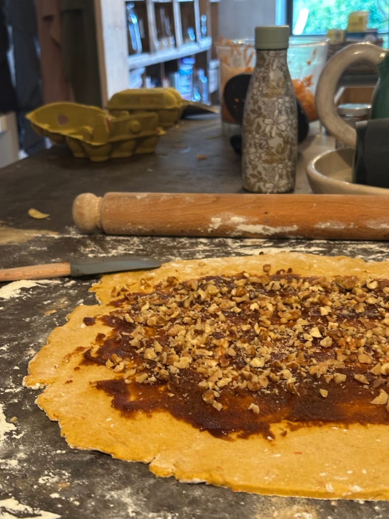 A pie crust filled with caramel and nuts, ready to be baked.