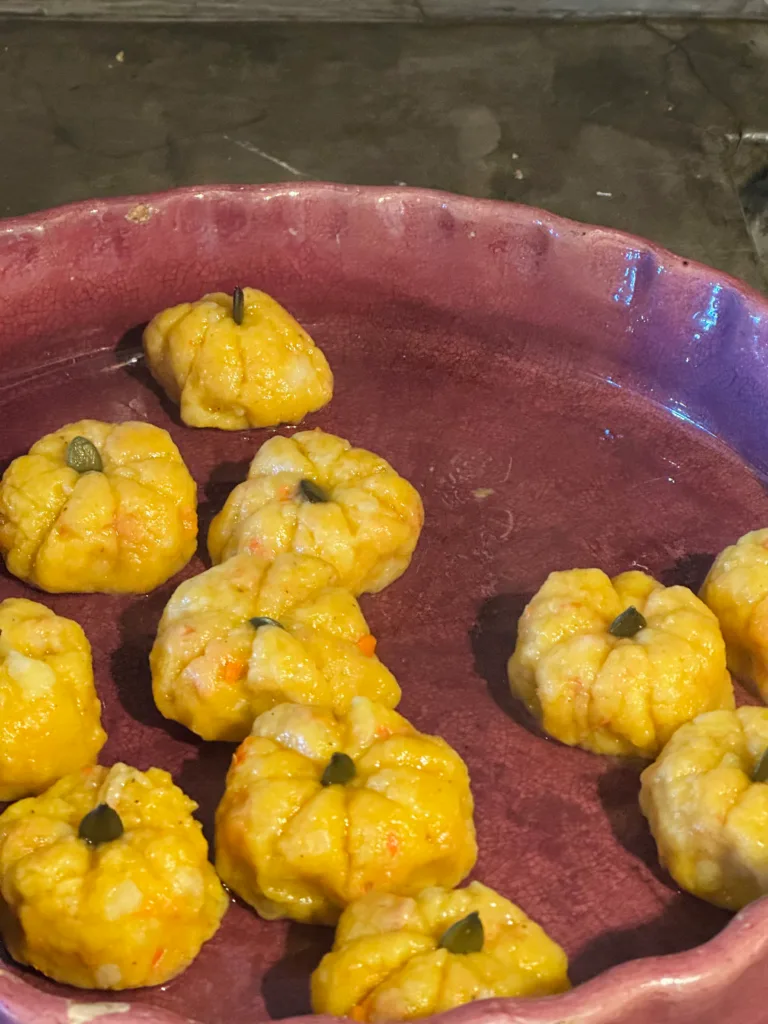 Des petites citrouilles dorées sur une assiette en céramique violette, un délicieux plat d'automne.