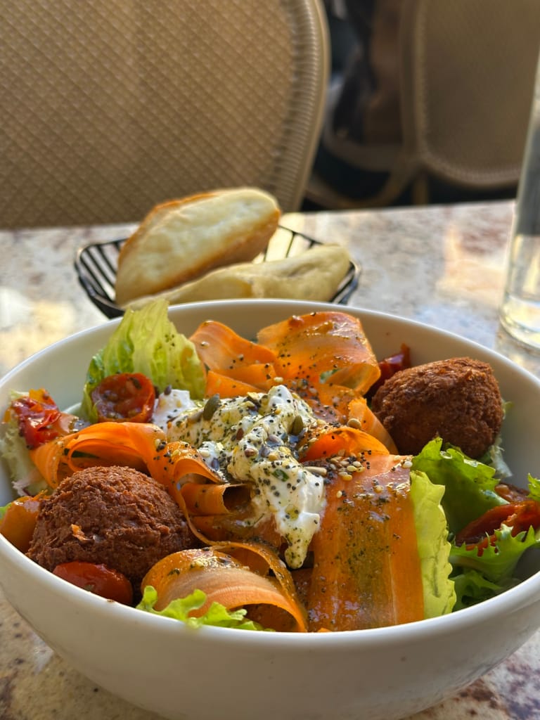 Salade colorée avec des légumes, des boulettes de viande et une sauce crémeuse, un repas sain et appétissant.