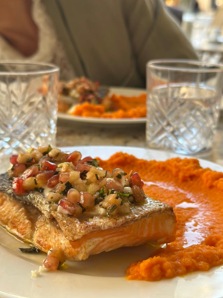 Un délicieux filet de saumon grillé, nappé d'une sauce aux grenades et accompagné de purée de patates douces.
