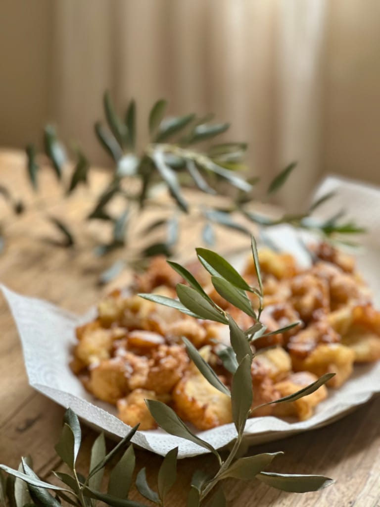 Des beignets moelleux et dorés, décorés de feuilles d'olivier, un délice sucré.