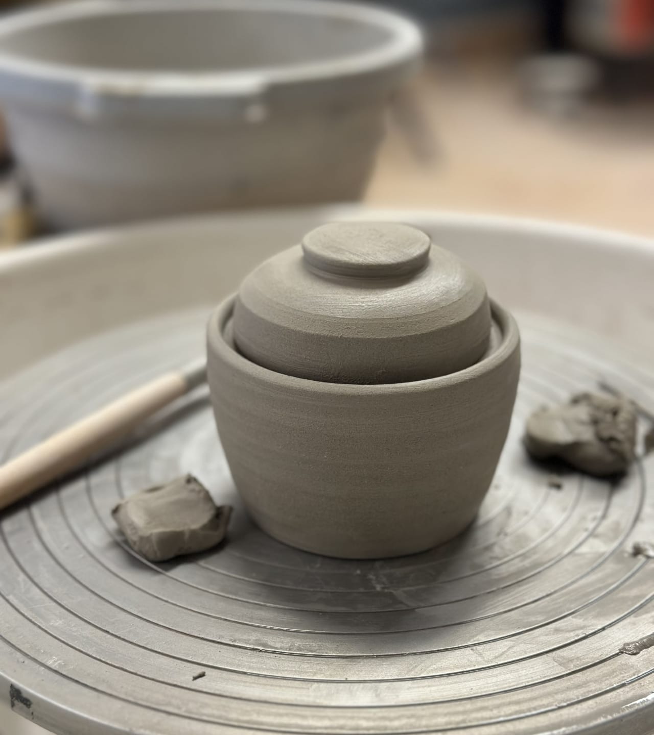 Des petits pots en céramique tournés sur un tour de potier, prêts à être cuits.