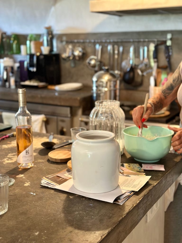 Une personne prépare une recette dans une cuisine, avec des ingrédients et ustensiles à disposition.