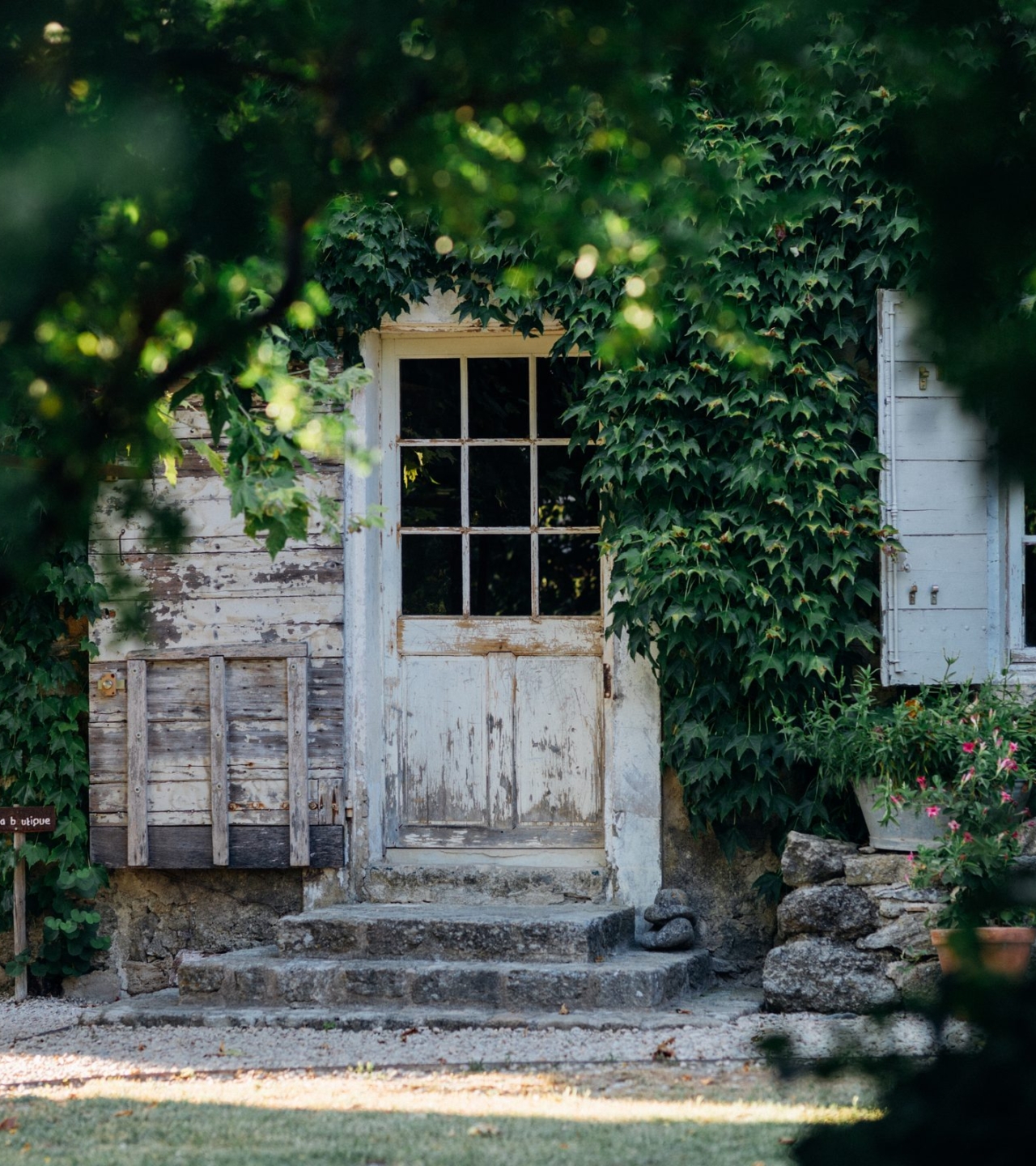 La porte de la ferme vue à travers les feuillages