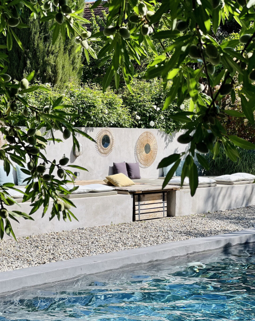 un chat assis sur un banc devant une piscine