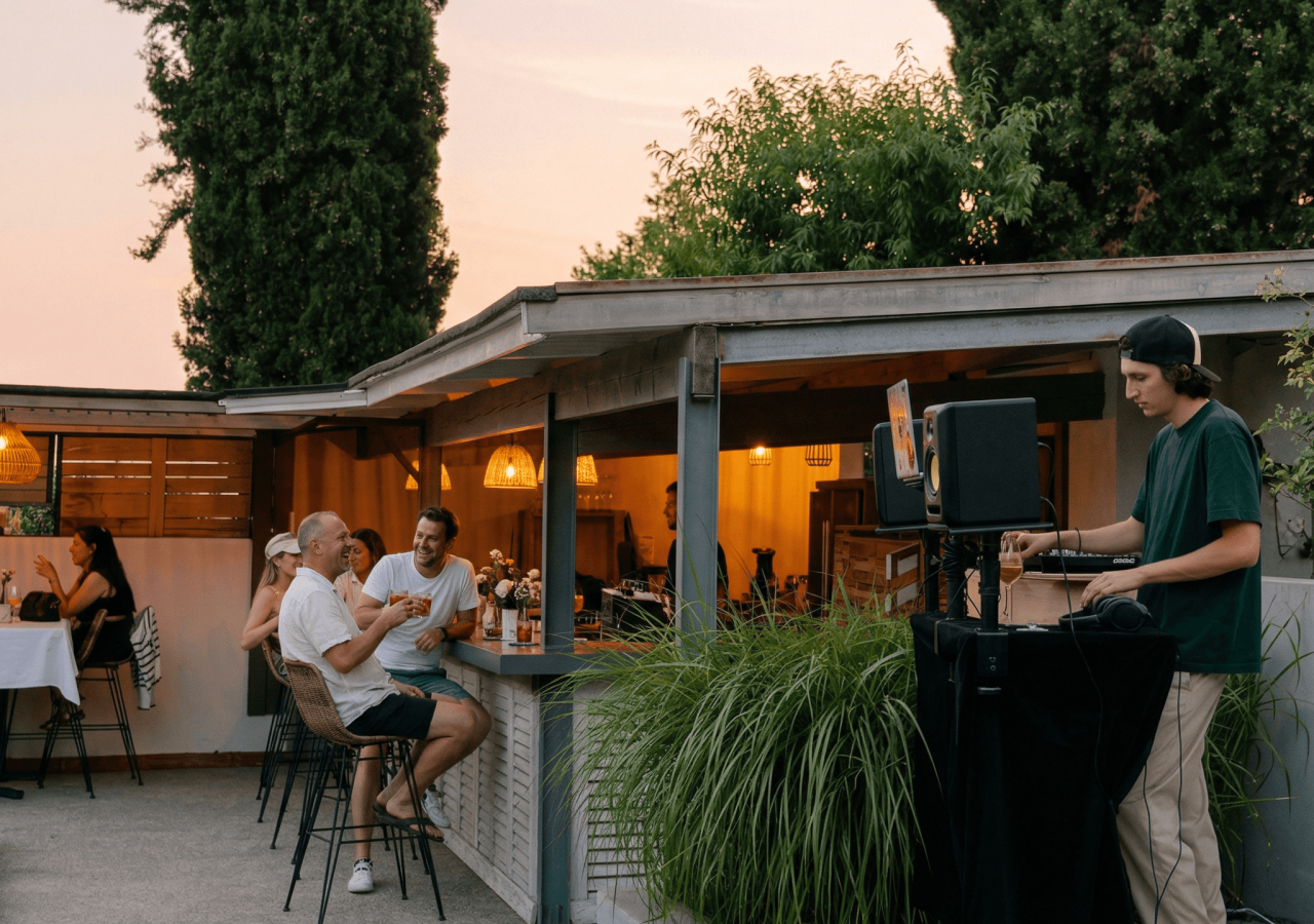 Ambiance conviviale en terrasse avec musique et dîner au coucher du soleil.