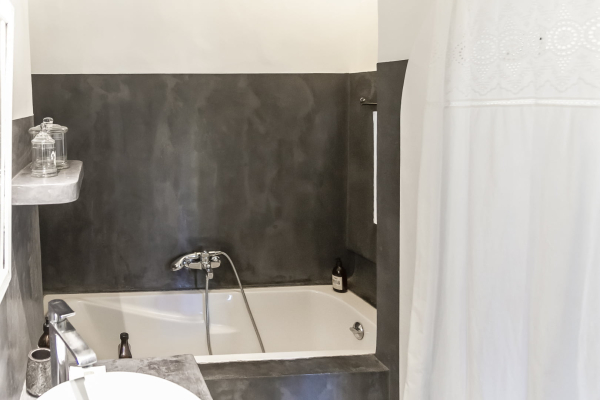 une salle de bain avec une baignoire, une évier, un miroir et une baignoire