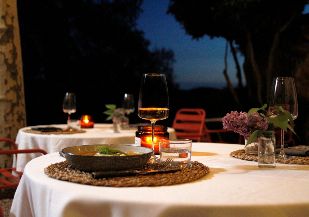 une table avec deux assiettes de nourriture et un verre de vin