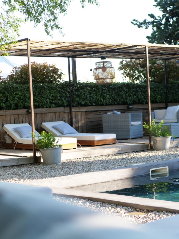 une zone de patio avec piscine, chaises et parapluies