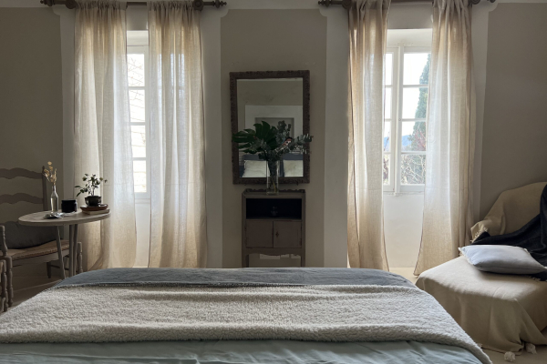 Chambre cosy avec rideaux en lin, un miroir et une literie confortable.