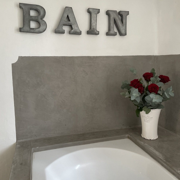 An elegant bathroom cabinet with red roses and a white vase.
