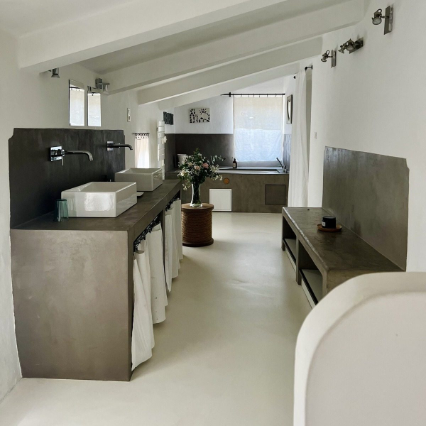Modern and minimalist bathroom with concrete walls and clean lines.