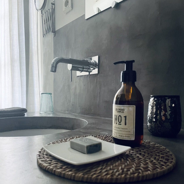 A stone sink with a soap dispenser and a decorative tray.