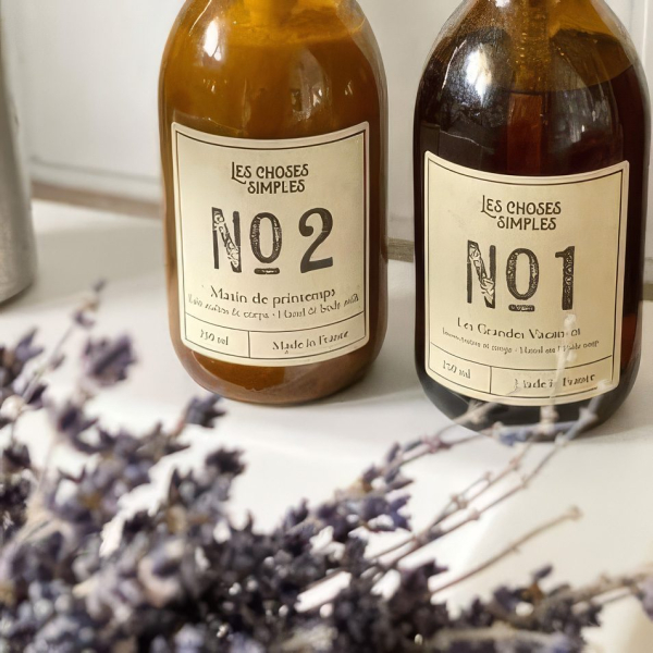 Zwei Flaschen Les Choses Simples Seife, Nr. 1 und Nr. 2, auf einer Arbeitsfläche mit Lavendel.