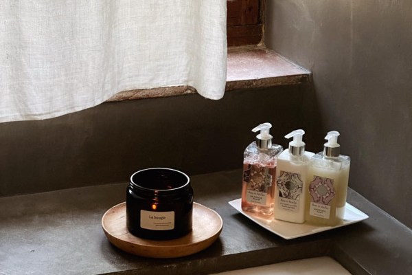 Bougies et savons artisanaux sur un rebord de fenêtre, ambiance cocooning et relaxante.